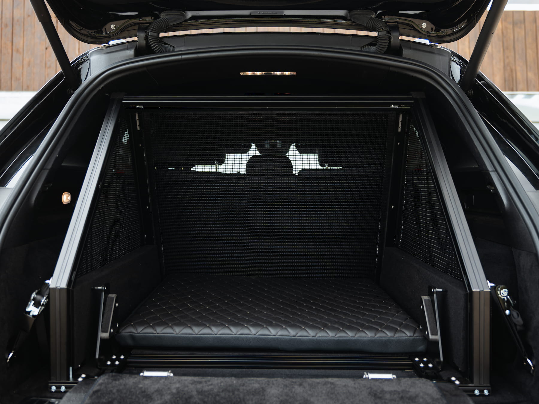 Made-to-measure Dog & Drive fibreglass-mesh crate with dog cushion installed neatly within the boot for secure, comfortable travel